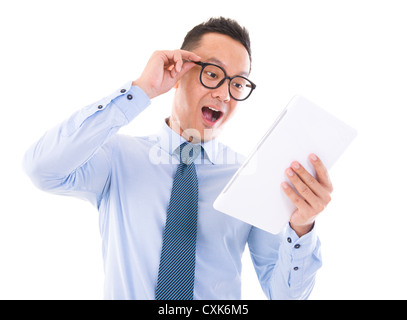 Surprise Asian business man looking at tablet computer, isolated over white background Stock Photo