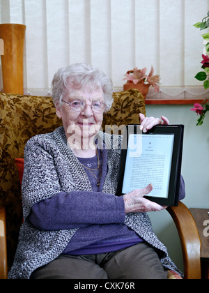 Happy and smiling 90 year old nonagenarian English pensioner delighted at receiving an iPad as her birthday present. England UK Stock Photo