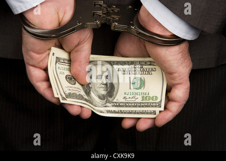 Dollar bills and handcuffs Stock Photo
