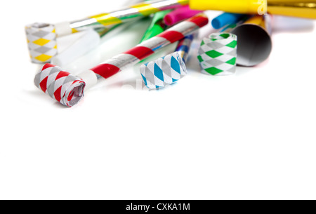 Assorted noise makers including red, silver, yellow, green, blue on a white background with copy space Stock Photo