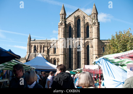 Hexham Abbey towers above the Hexham Farmers Market in Hexham, Northumberland, England. Stock Photo