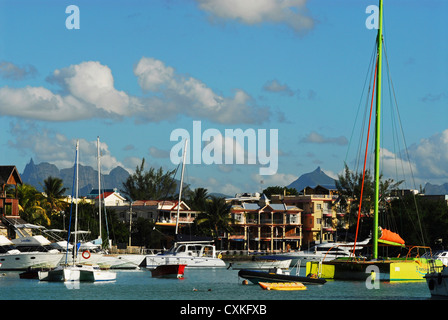 Mauritius, Grand Baie, boats anchored on river with cottages in the background Stock Photo