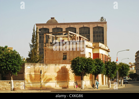 Eritrea, Asmara, people walking on pathway, bus on street with buildings in the background Stock Photo