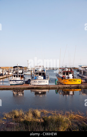 Port of Ilwaco at south end of Long Beach Peninsula in evening light with moored fishing & charter boats Washington State Stock Photo