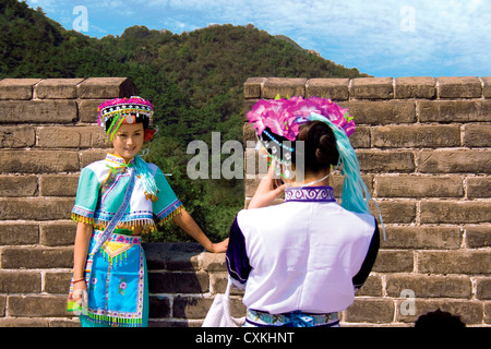 China, Badaling, Great Wall, Two women dressed in traditional minority clothing pose for a digital photo. Stock Photo
