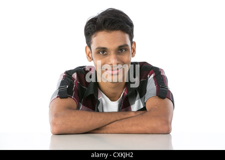 Indian man leaning on a white table and looking at camera. Isolated on white background Stock Photo