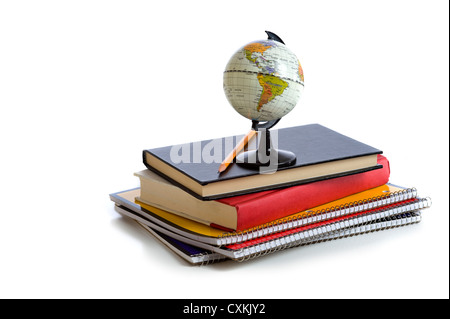 A stack of school books and notebooks with a miniature globe Stock Photo