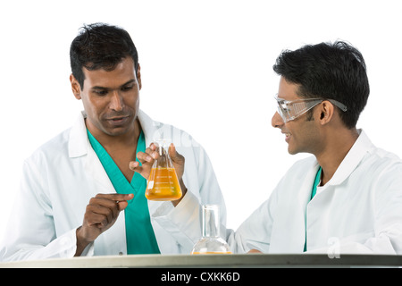 Two Indian scientists analyzing solution. Stock Photo