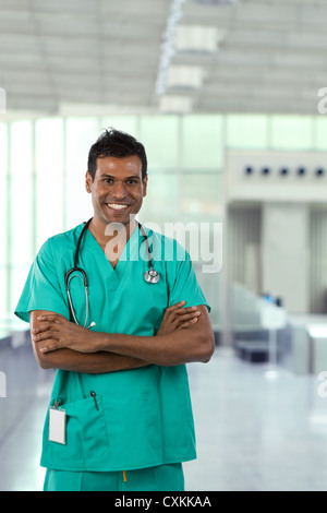Male Indian Doctor wearing Green Scrubs in modern hospital. Stock Photo