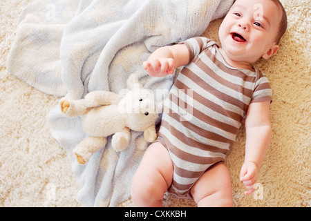 Happy baby laying on rug Stock Photo