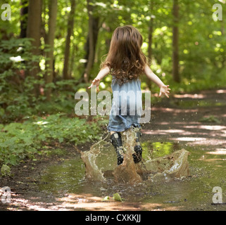 Little girl jumping in puddle Stock Photo