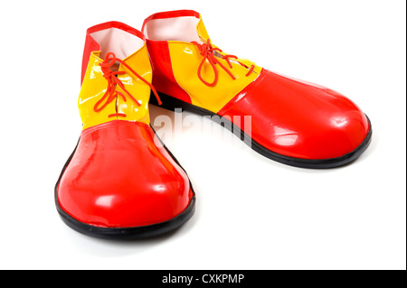 A pair of oversized red and yellow clown shoes on a white background Stock Photo