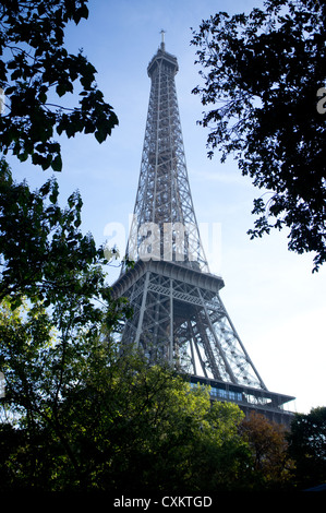 The Eiffel Tower in Paris, France seen through trees on a sunny day. Stock Photo