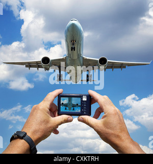 Hands holding Digital Camera Photographing Jumbo Jet Landing at Pearson Intermational Airport, Toronto, Ontario, Canada Stock Photo