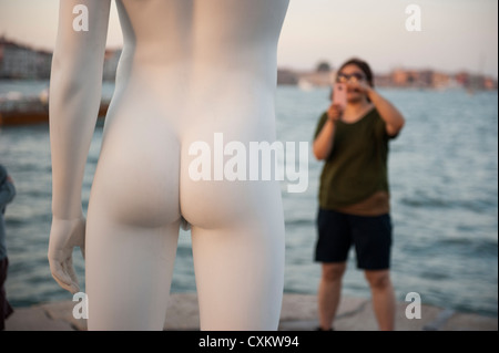 A tourist taking pictures to the Charles Ray's statue 'boy with a frog', Venice, Italy. Stock Photo