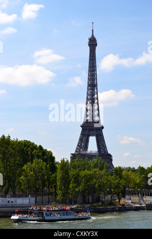 The Eiffel Tower, Paris seen from a bridge over the River Seine, as a tourist boat goes by. Stock Photo