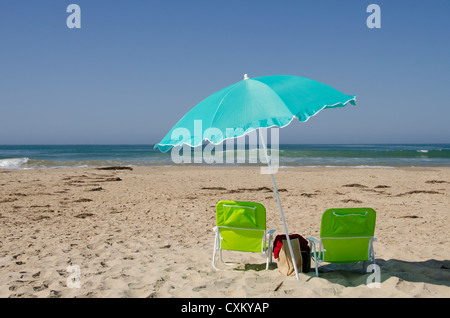 California, Pacific Coast, Pismo Beach. Beach umbrella & empty chairs on Pismo State Beach. Stock Photo