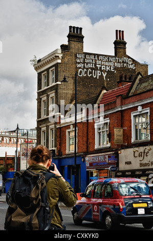 photographing the “we will take occupancy' message on the wall, East London Stock Photo