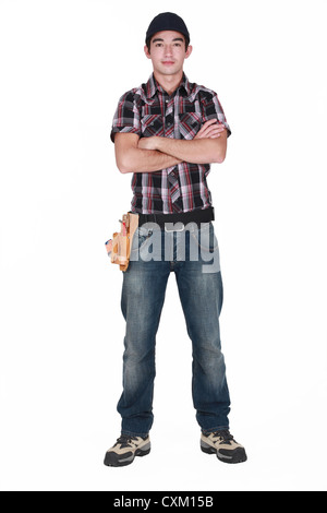 Young builder stood with arms folded Stock Photo