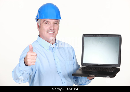Thumbs up from an engineer with a laptop Stock Photo