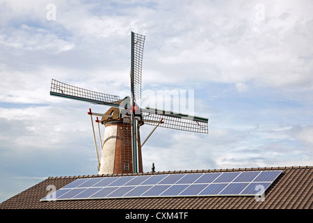 windmil and solar panels on roof of shed Stock Photo