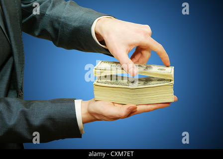 Hand with money isolated on blue background Stock Photo
