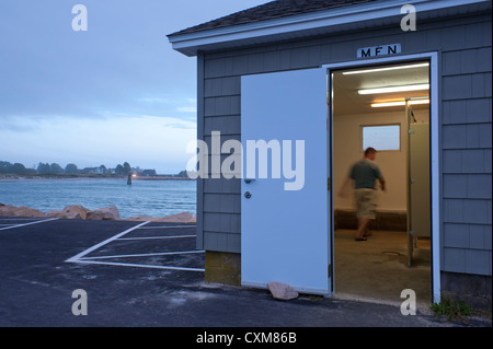 Man entering a stall in a public restroom. Stock Photo