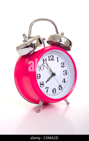 a bright pink vintage looking alarm clock on a white background Stock Photo