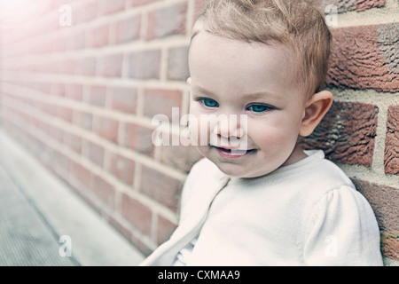 Beautiful Baby Girl against Brick Wall Stock Photo
