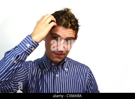 Good looking young man scratching his head, worried, confused or thinking Stock Photo