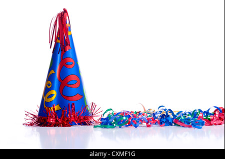 A brightly colored birthday hat and streamers on a white background with copy space Stock Photo