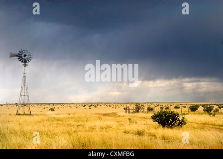 Windmill in a Texas field along Route 66 with a storm approaching Stock Photo