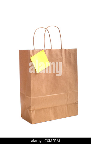 A brown shopping bag with handles with a post-it note or sticky note attached on a white background Stock Photo