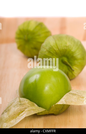 Three fresh tomatillos on a cutting board Stock Photo