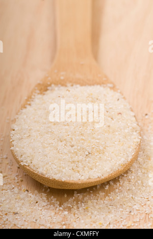 Fresh grits on a wooden spoon in preparation for cooking Stock Photo
