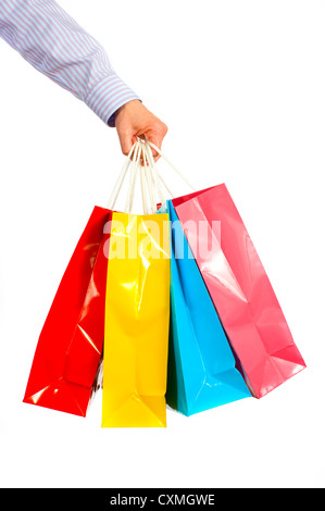 A ladies hand gripping several brightly colored shopping bags on a white background Stock Photo