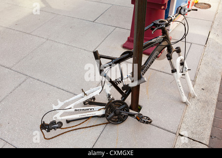 Vandalized bicycle on street sign post (vandalized bike frame) - USA Stock Photo