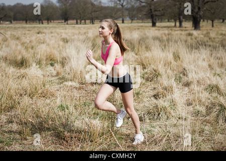 Young woman running outdoors in a park for exercise Stock Photo