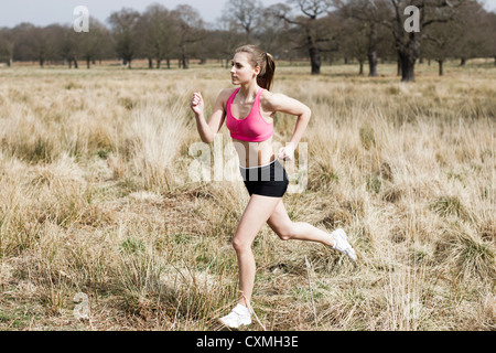 Woman runner running through a park Stock Photo