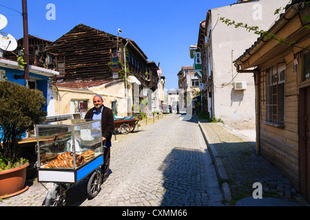 Simit seller in a lane full of traditional wooden houses, Istanbul, Turkey Stock Photo