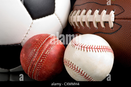 Assorted sports balls including a soccer ball, American football, baseball and cricket ball as a background Stock Photo