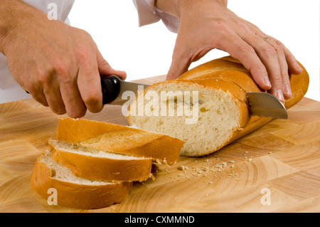 slicing bread on wood cutting board with a bread knife Stock Photo