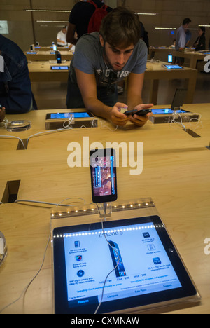 New York, NY, USA, American Teen in Apple Store, Looking at Iphone, Smart Phones, Ipad Tablets, in Grand Central Train, Manhattan Consumer Products, People using new exciting technology. apple showroom, young people buying mobile, shopper iphone Stock Photo