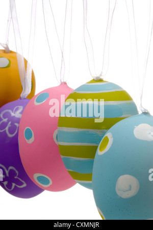 Row of pastel decorated Easter eggs hanging on a white background Stock Photo