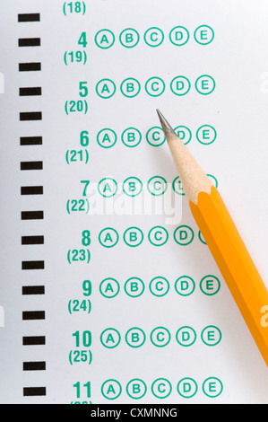 a yellow pencil lying on a multiple choice test or exam answer sheet Stock Photo