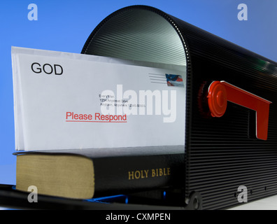 Mail box containing Holy Bible on white background, symbolizing that the Bible is a message or mail from God Stock Photo