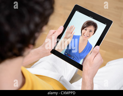 Man and woman communicate through video chat on modern digital tablet. Stock Photo