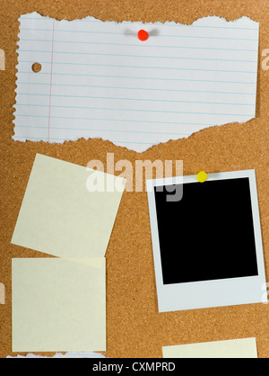 Bulletin board with blank post-it notes, notebook paper and Polaroid available for copy space Stock Photo