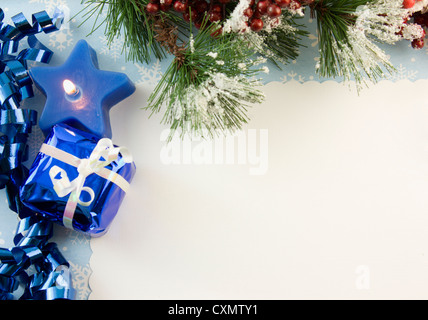 blank Christmas card with blue star candle, ribbon, present, icy fir branch and copyspace Stock Photo