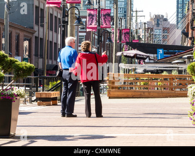 Mature Couple Strolling through Yaletown Neighborhood in Vancouver, Canada Stock Photo